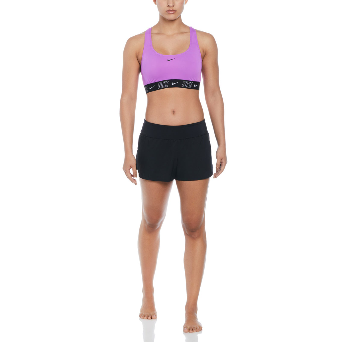 Person wearing a purple Nike sports bra and black shorts on a white background