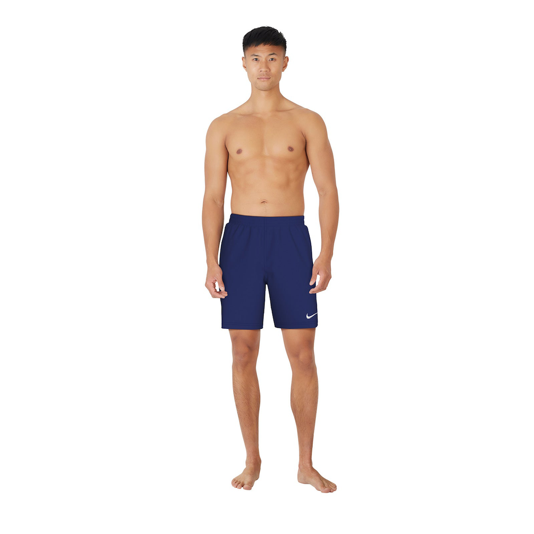 Man wearing navy swim shorts with a white logo on a white background